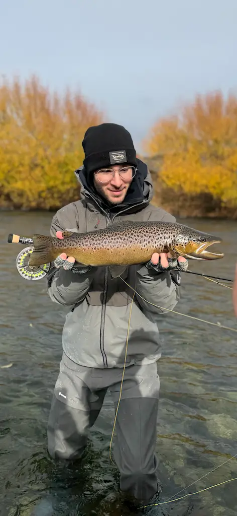 Mateo co-founder holding brown trout fly fishing in Patagonia river