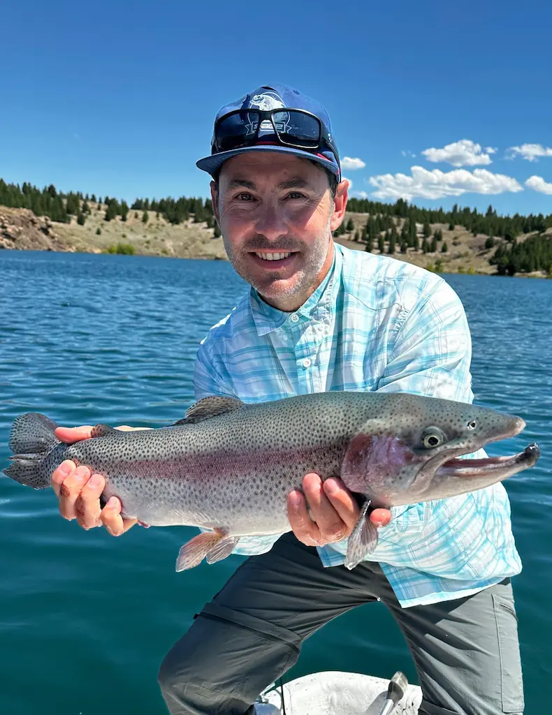 Nico co-founder holding rainbow trout fly fishing at Stone River Lodge