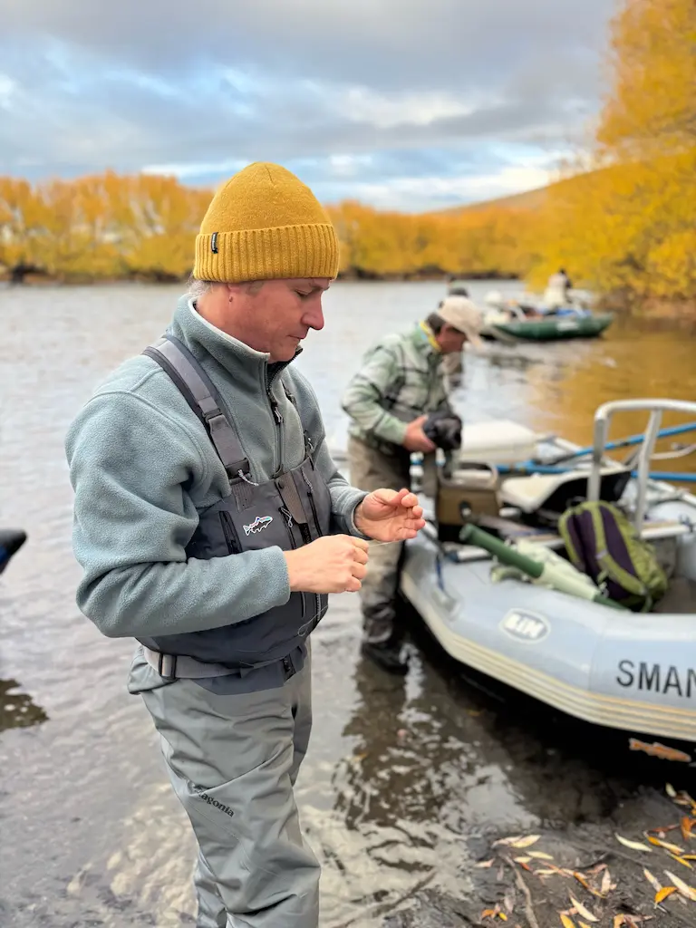 Nachi host and lodge manager preparing fly fishing gear on boat