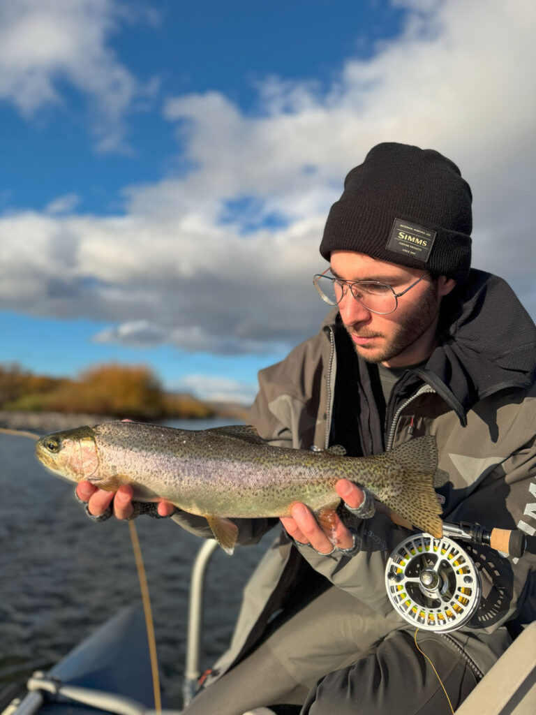 Angler holding rainbow trout catch fly fishing in Patagonia river