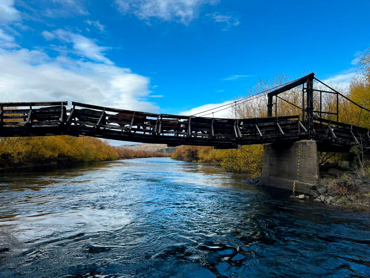 Rustic wooden bridge crossing river near Stone River Lodge Patagonia