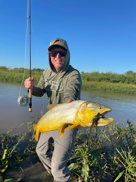 Jon Quigley client testimonial holding large golden dorado catch