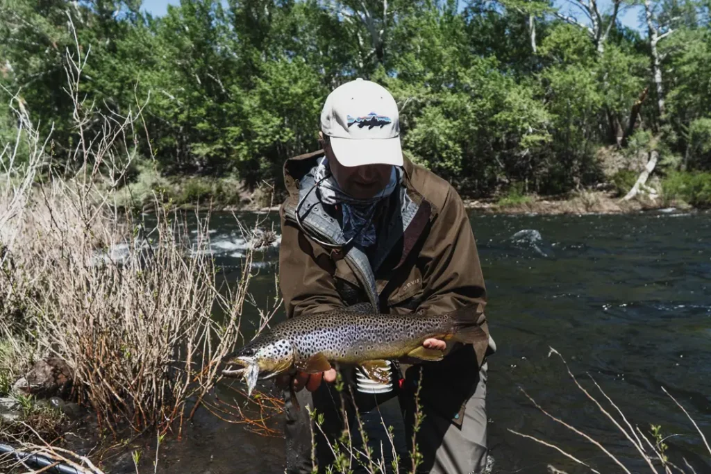 Angler casting fly line on river at Stone River Lodge