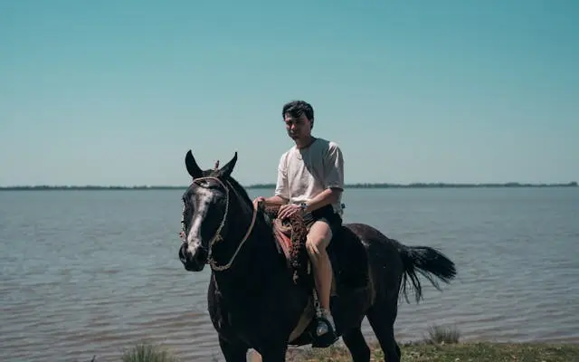 Guest enjoying horseback riding experience near river in Argentina