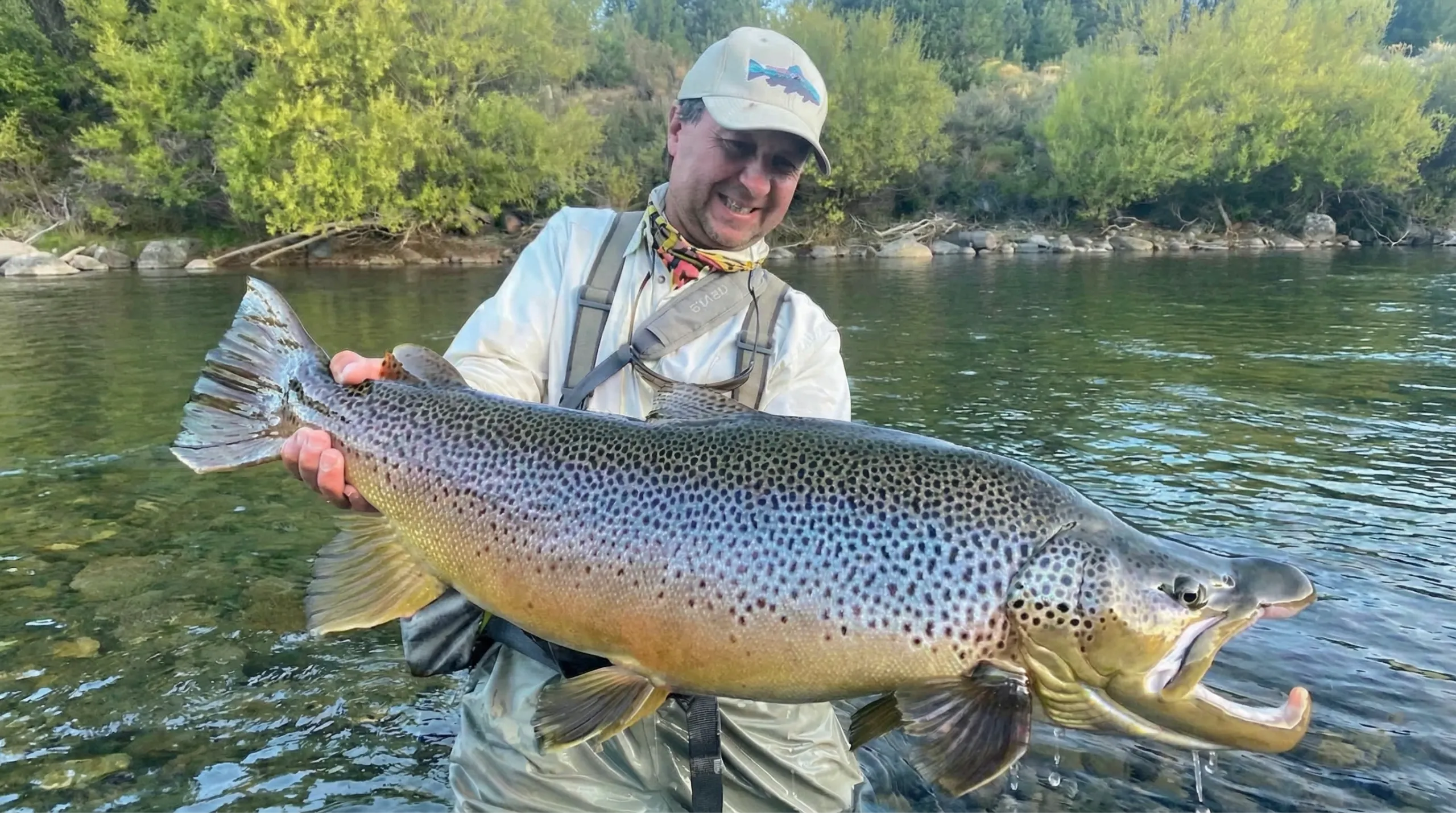 Fly fisherman casting at sunset in a Patagonia trout river
