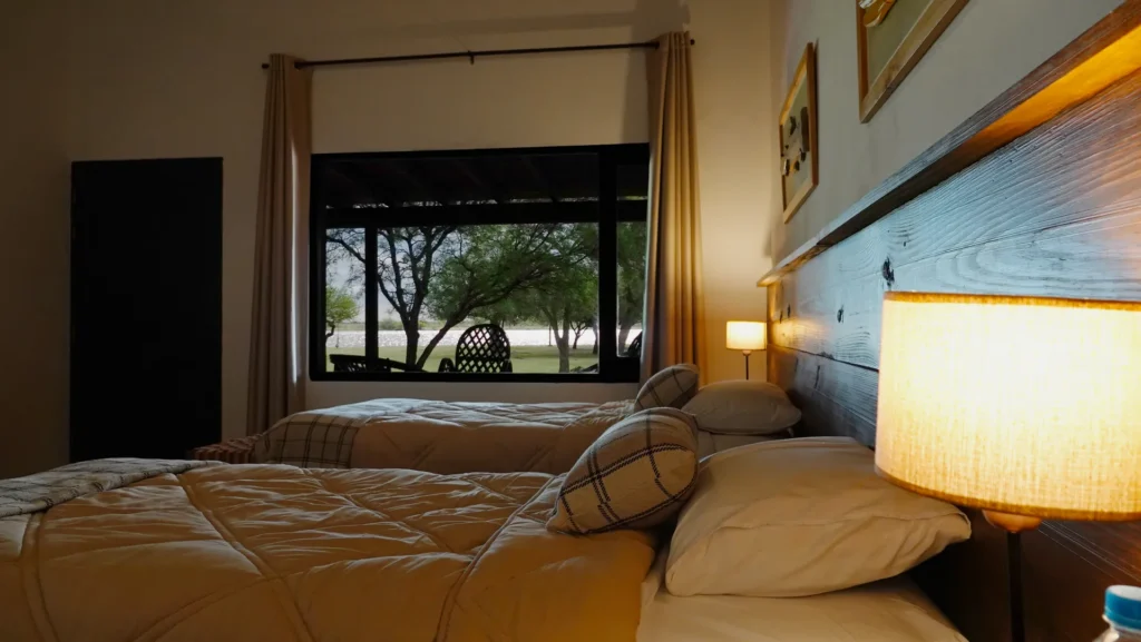 Luxury twin bedroom interior with large windows at Golden Dorado Lodge
